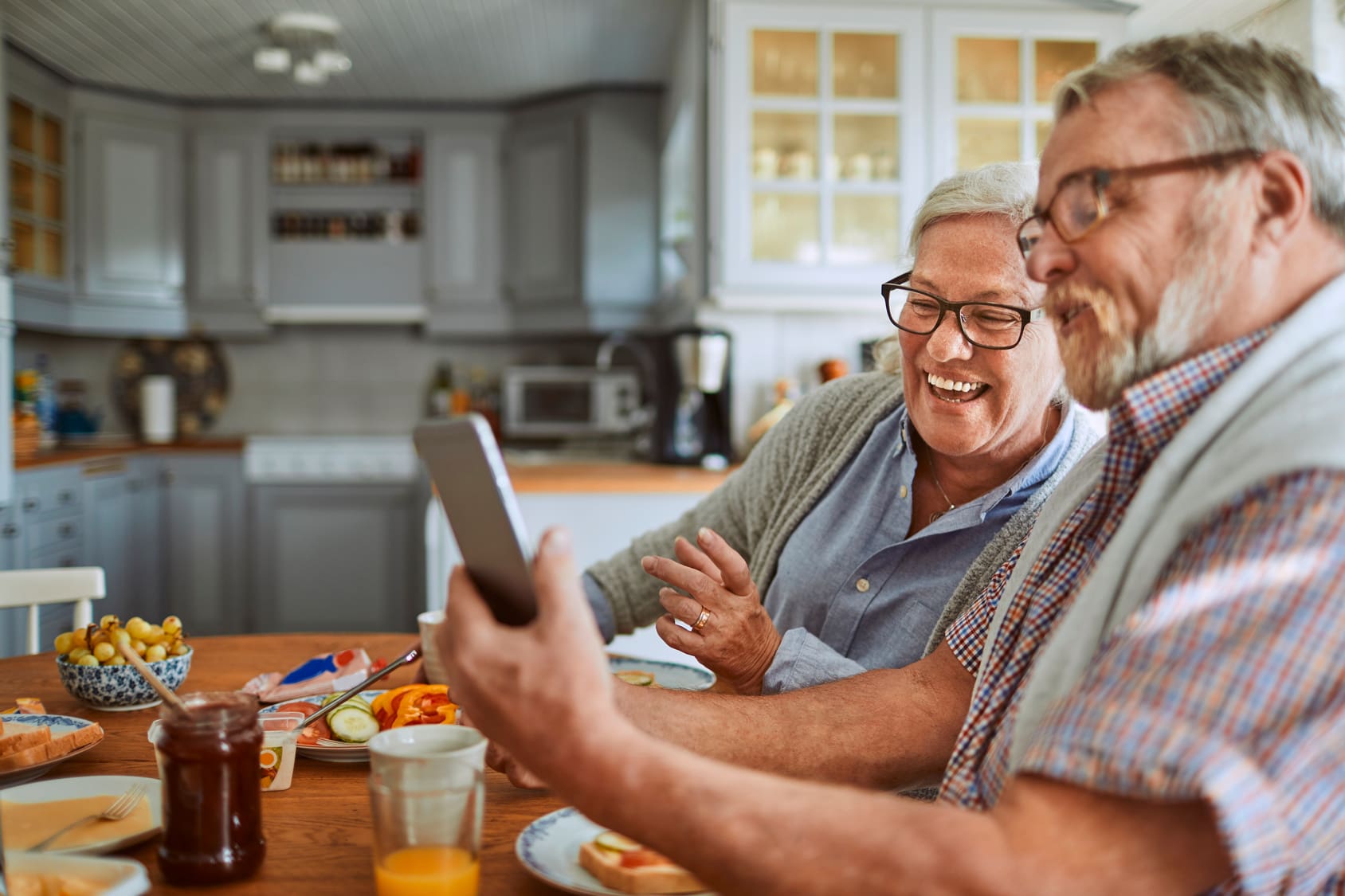 senior couple breakfast home smartphone
